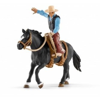 Kovboj osedlající divokého koně